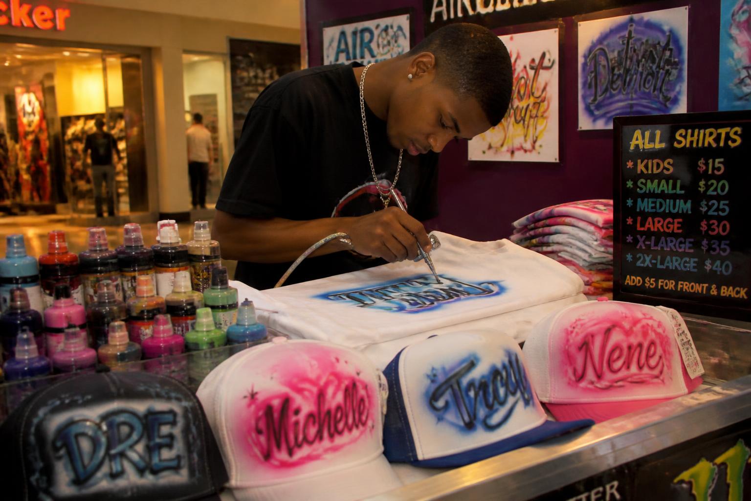 2005 mall kiosk in Detroit with custom airbrushed shirts and hats